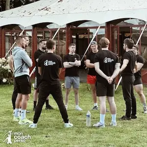 Groupe de coachs sportifs Mon Coach Perso réunis en extérieur lors d’un échange collectif et professionnel.
